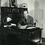 Photo of Walter Havighurst sitting at desk.
